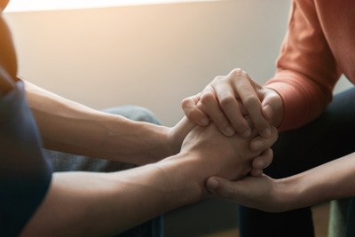 two people showing their support for each other to identify their focus on helping to change directions away from crutch of addiction