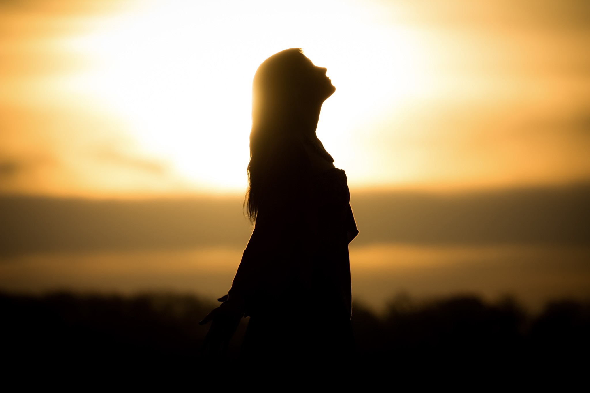 woman stretching in front of a sunset to lose stress anxiety and addiction through a plan reviewed by an outpatient addiction counselor