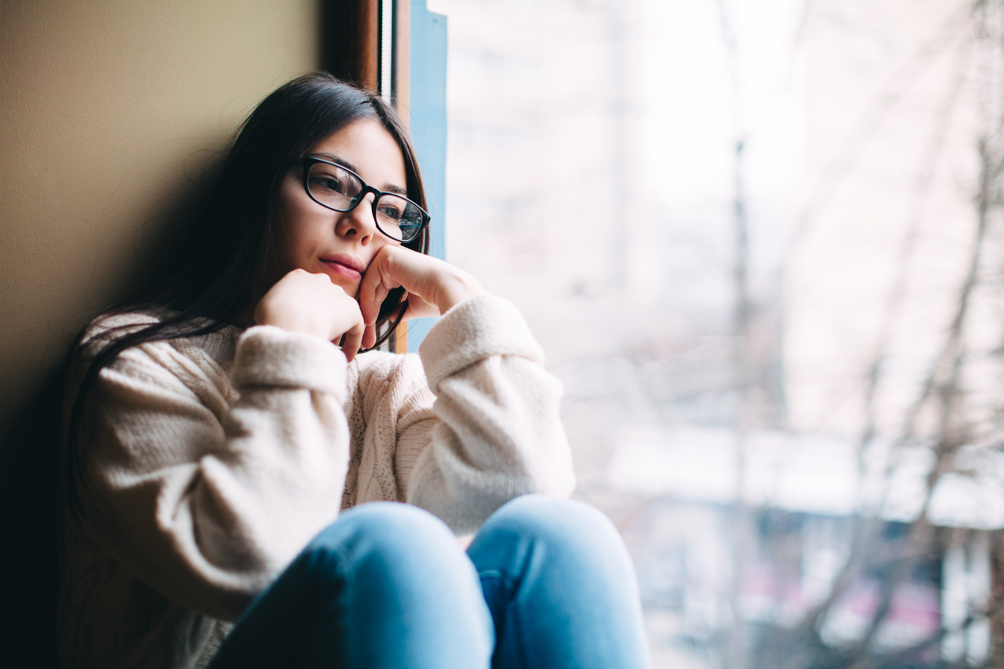girl looking out the window with hope that her future will relieve struggles with mental health and addiction so she can get help at A and D Psychotherapy